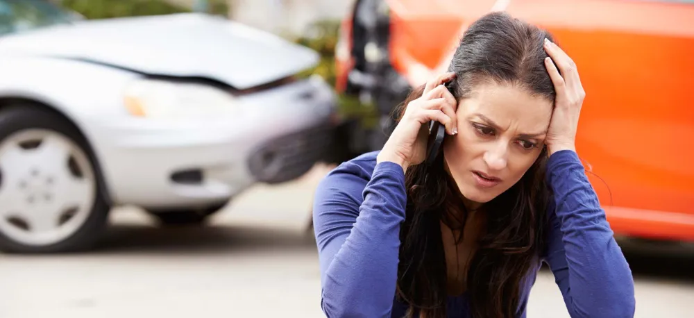 Woman on the phone after a car accident