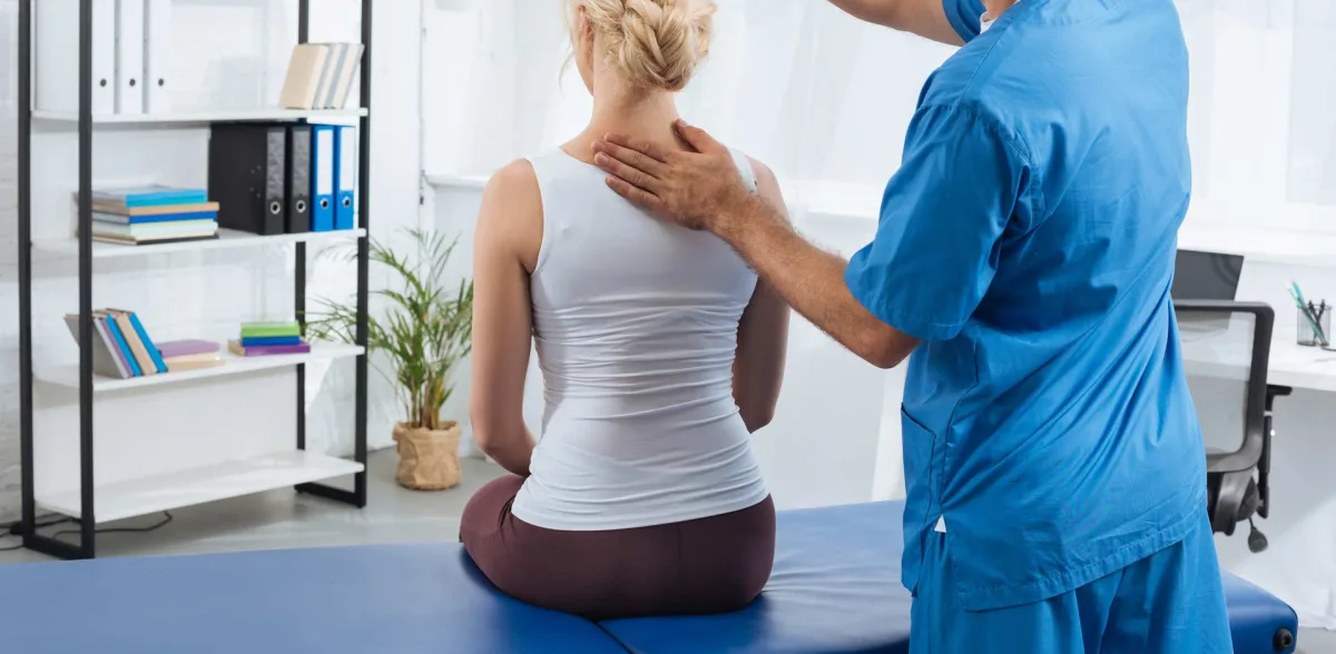 Chiropractor examining a patient's neck and upper back